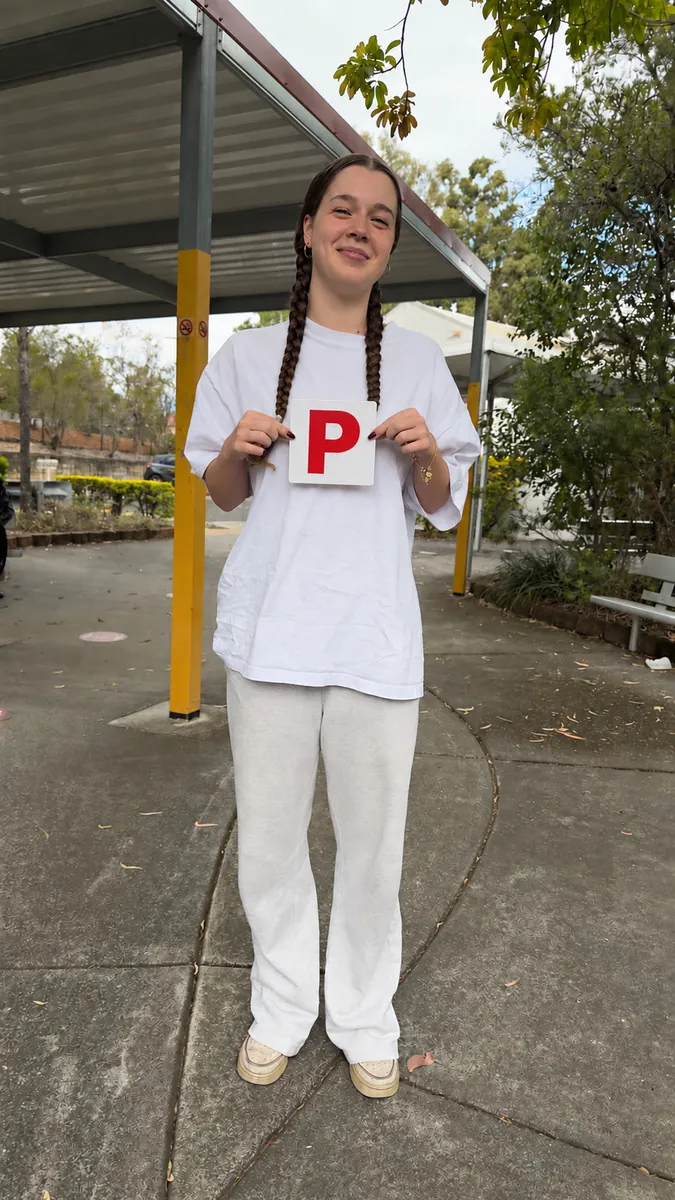 Madeleine holding her P plate after passing first go at Ipswich