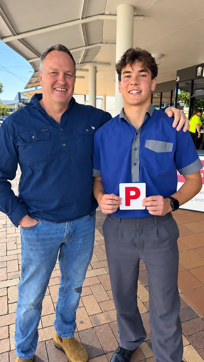 Bubby with his dad, holding his P plate after passing in a manual at Sherwood